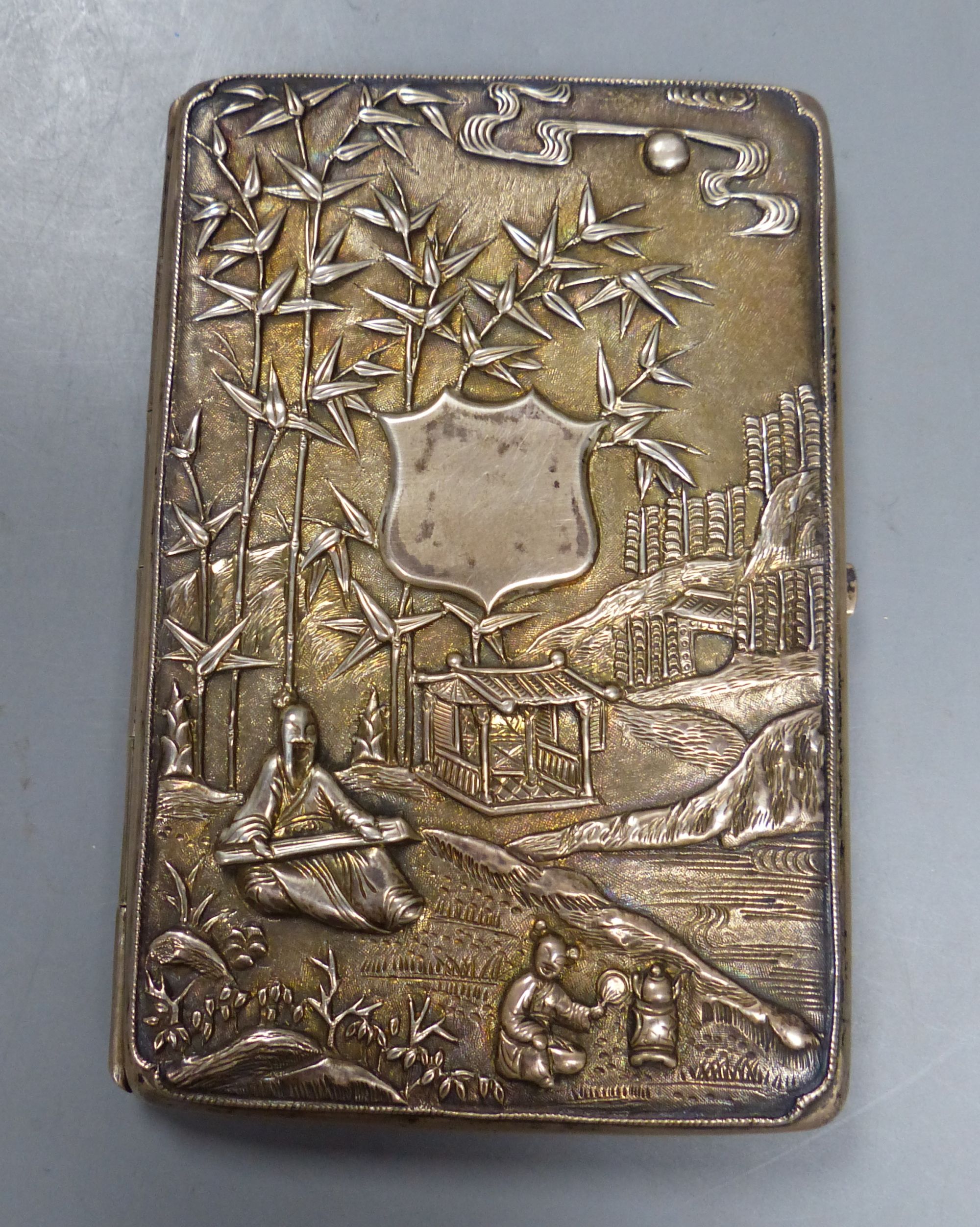 A late 19th century Chinese Export white metal card case, decorate with figures at various pursuits in landscape scene,